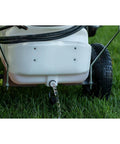 Rear view of Tow-Behind Garden Sprayer With 15 Gallon Tank, 30 Inch Boom, 1.6 GPM At 100 PSI showing tank drain in garden setting