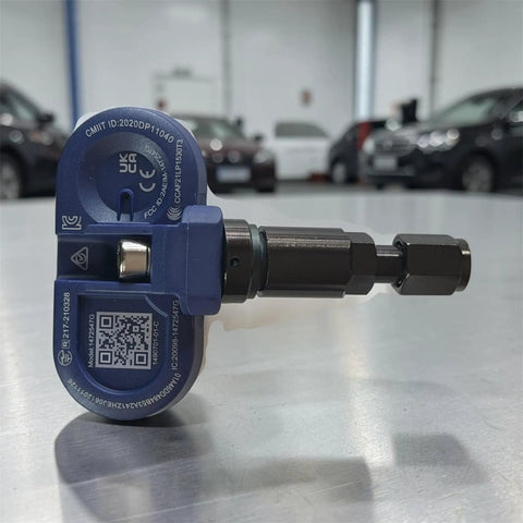 Wireless Bluetooth TPMS Tire Pressure Monitor with metal valve stem for Tesla vehicles, side view on silver surface.