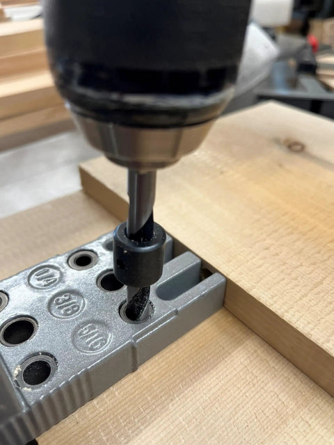 Close-up of a drill using Pro Doweling Kit With Pre-Aligned Hole Guides And Hardened Steel Bushings for uniform joints in wood.