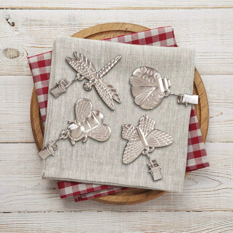 4 Pack Tablecloth Weights With Metal Clips Clamps For Outdoor Parties And Picnics, Cast Iron Weights In Butterfly Bee Dragonfly And Ladybug Shapes, displayed on cloth napkin