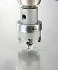 IDEAL carbide hole cutter head cutting metal, front view; silver-colored with IDEAL logo
