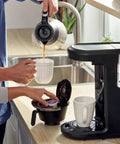 Person brewing coffee with 12-cup programmable maker and Advanced Water Filter Cartridges For 12-Cup Programmable Coffee Makers, 2 Pack White