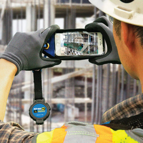 Worker using Pro ToolMate Retractable Tool Tether And Smartphone Jacket Kit, 1 lb lanyard, ANSI 121 Certified, in outdoor setting.
