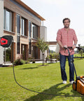 Heavy Duty Built Tough 50 Foot Retractable Extension Cord Reel With Three Grounded Outlets Lighted Triple Tap For Outdoor Use mounted on house