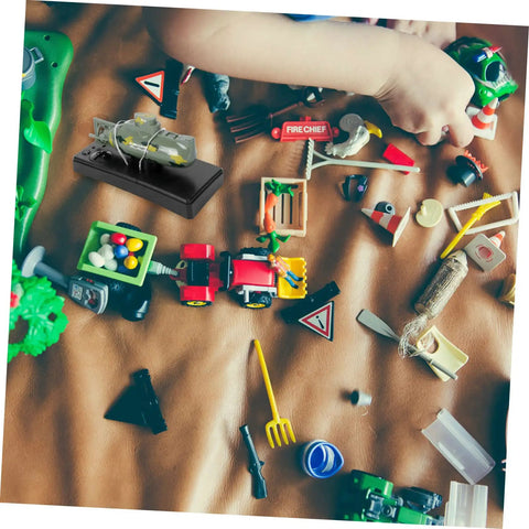 Child playing with RC Submarine Mini Boat Rechargeable Plastic Dark Green Military Dive Model among various toys on a brown surface