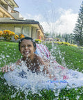 Child playing on Stars And Stripes Kids Inflatable Backyard Water Slide With Built In Splash Pool Over 14 Feet Long Quick Setup In Under A Minute Connects To Standard Garden Hose Blue Backyard Summer Fun For Active Kids in garden area.