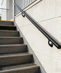 7FT Modern Aluminum Wall Mount Handrail Matte Black installed on outdoor steps with sturdy zinc brackets for added support.