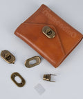 Brass turn-lock purse hardware set; includes multiple plates and fasteners on brown leather wallet display