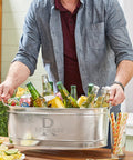 Person holding Personalized Galvanized Beverage Tub With Name And Initial For Parties, Custom Drink Cooler, filled with drinks