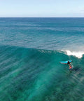Person surfing with Alien Wing 6M High Performance Wind Wing For Foiling And Surfing Lightweight Aerodynamic Rigid Wing Includes Backpack Wrist Leash And Repair Kit Tri Color on ocean wave