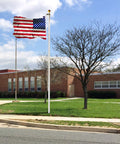 Heavy Duty 25 Foot Flag Pole Kit With 3x5 Foot US Flag Aluminum Outdoor Flagpole With Gold Ball Top weatherproof in front of a building