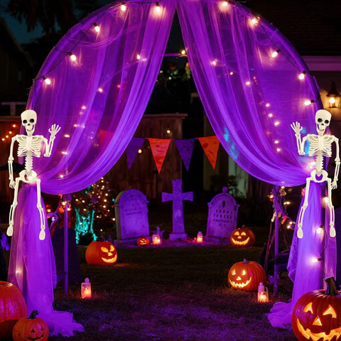 Two 15.7 Inch Hanging Skeleton Decorations With Full Body Posed Joints in Halloween graveyard scene with lights and pumpkins