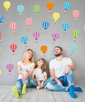 Family sitting under 45 Piece Colorful Hot Air Balloon Cutouts For Bulletin Boards And Classroom Decor, 9 Styles With Easy Glue Dots.