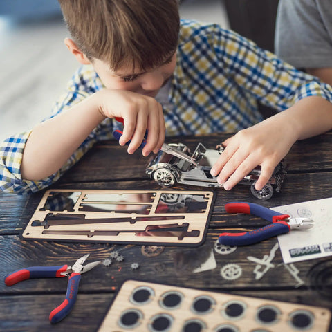 Child using Mini Pliers Set 3-Piece Handy Tool Kit With 4 Inch Diagonal Pliers, 5 Inch Long Nose Pliers, and 6 Inch Needle Nose Pliers for crafting model car.