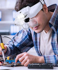 Person using Hands Free Headband Magnifier With Light Rechargeable 1X To 14X Headset Glasses for soldering electronics