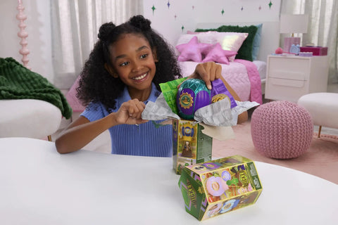 Child unboxing Unbox Wicked Ozian Balloons Reveal Toy Set With Surprise Mini Doll Inside Each Balloon on table.