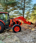 Tractor with Stump Bucket for Tractors and Skid Steers Up To 105 HP removing stump in a wooded area