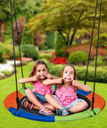 Two kids playing on 40 Inch Kids Saucer Tree Swing Set With 600D Heavy Duty Oxford Fabric Platform Seat, outdoor view