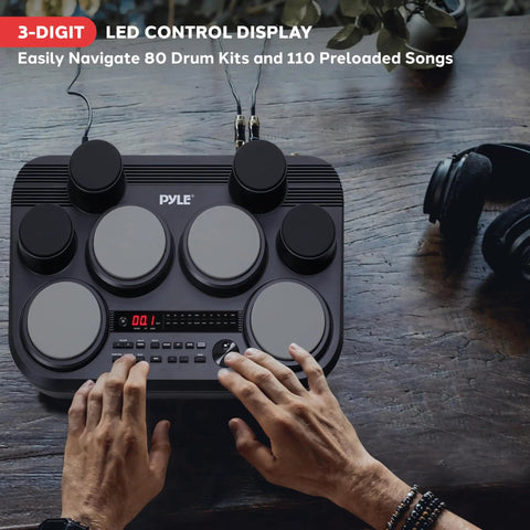 Person playing Compact Tabletop Electronic Drum Pad Kit With 8 Touch Sensitive Pads And Pedals, 600 Sounds on wooden surface.