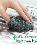 Hand using three pack stainless steel dish scrubbers that power through tough grease and burnt on messes on a metal surface
