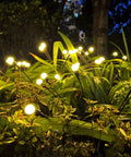 8 Pack Solar Garden Lights With 64 LEDs Starburst Firefly Pathway Lights That Sway In The Wind illuminating garden foliage at night