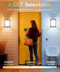 Woman approaches yellow door lit by Two Pack Dusk To Dawn LED Outdoor Wall Sconce With Adjustable 3000K 4000K 5000K Color Temperature