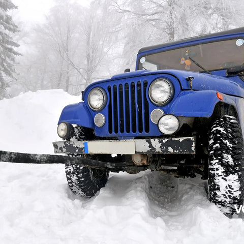 Beefed-Up Heavy-Duty Synthetic Winch Rope 50 Ft Quarter Inch, 10,000 Lb Load Rating For ATV SUV And Truck attached to a jeep in snow