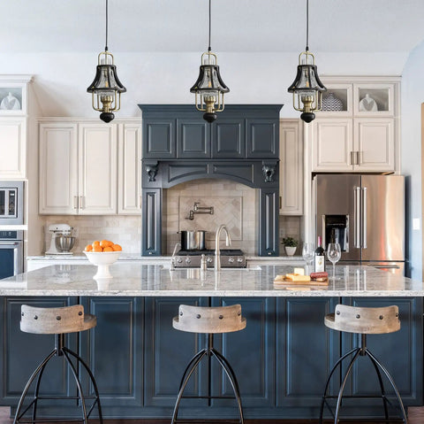 Farmhouse Pendant Light With Crackle Glass Shade In Matte Black Metal Cage Base above a kitchen island with bar stools.