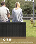 People sitting on a 100 Gallon Waterproof Resin Deck Box With Lockable Lid For Patio Cushions And Garden Tools, Large Outdoor Storage Chest For Indoor Or Outdoor Use Black Weatherproof in a garden.