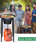Group cooking on Beefy 75,000 BTU Dual Burner Portable Gas Camp Stove with 20 PSI regulator during outdoor party