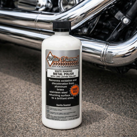 Bottle of Metal Polish With Long Lasting Sealant Cleaner Polisher Protectant All In One beside motorcycle chrome pipes