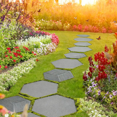 Two-Size Hexagon Stepping Stone Molds for Concrete installed in a garden path among colorful flowers and green grass.
