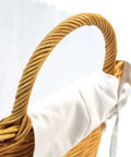 Close-up of a handle on the Rattan Laundry Basket With Easy Carry Handles And Removable White Cotton Liner, Natural Wicker Hamper