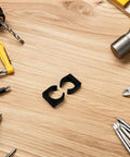 Two Pack Nylon Water Pipe Clamps For Marine Use on wooden table surrounded by tools