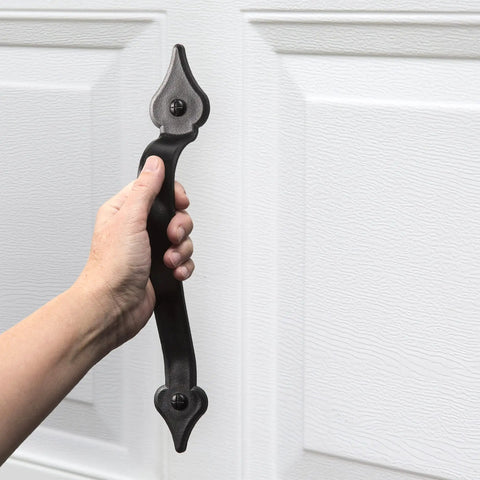 Hand holding part of Magnetic Garage Door Hardware Kit 6 Piece Made From UV Stabilized ABS Plastic No Rust Or Flake Kid And Pet Safe Includes Two 12-Inch By 2-Inch Magnetic Handles For Quick Easy Install