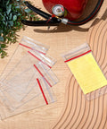 Heavy Duty Resealable Fire Extinguisher Tag Covers 100 Pack Crystal Clear Waterproof Plastic Inspection Sleeves displayed with a notepad.