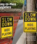 Heavy Duty Slow Down Kids Playing Neighborhood Warning Sign Crafted From Tough 63 Mil Aluminum, displayed on brick and tree.