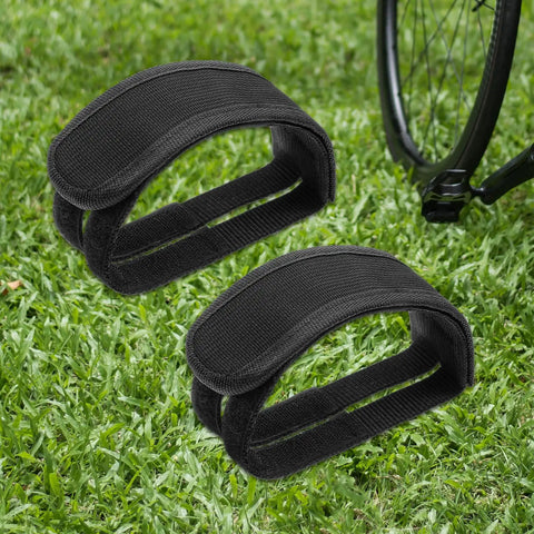 2 Pack Bike Pedal Straps Toe Clips Straps Adjustable Anti Slip Cycling Foot Straps For Kids And Adults Durable Nylon With Reinforced Stitching Easy To Install Comfortable Fit Great For Leisure Or High Intensity Rides on grass next to a bike wheel