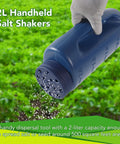 2L Handheld Spreader Set With Adjustable Dial And 7 Opening Modes For Seeds Fertilizer Salt And More Includes Two Scoops Green And Blue The Handy Yard Workhorse For Home Garden Or Farm Use, being used in a field