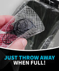 Person holding a used disposable drain hair catcher mesh strainer sticker above a trash can, demonstrating easy disposal.