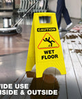 Bright Caution Wet Floor Sign 24 Inch Folding A Frame Double Sided 4 Pack Portable Safety Sign For Busy Walkways High Visibility Yellow Indoor Use Ideal For Commercial Kitchens Hospitals Warehouses And Schools. Yellow folding wet floor A-frame sign on a wet floor.