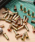 100 Pcs 1/4-20 Rivet Nuts Multi Grip Threaded Insert Nut Kit Zinc Plated Steel Flat Head Nutserts on a workbench