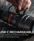 Close-up of hand plugging USB-C cable into 12,000 Lumen Handheld Flashlight With 5 Lighting Modes USB-C Rechargeable Waterproof Tactical Floodlight For Hiking Camping Hunting Self Defense And Go-To Outdoor Adventures.