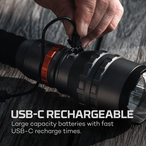 Close-up of hand plugging USB-C cable into 12,000 Lumen Handheld Flashlight With 5 Lighting Modes USB-C Rechargeable Waterproof Tactical Floodlight For Hiking Camping Hunting Self Defense And Go-To Outdoor Adventures.