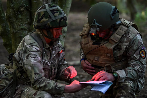 Two soldiers using Sidewinder 55 Lumen Compact II Military Flashlight With Helmet Mount illuminated in red during tactical mission