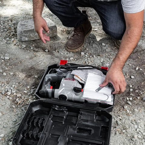 Man assembling Beast 1200W Electric Rotary Hammer SDS Plus Drill With Swivel Handle and chisels in carrying case outdoors