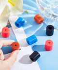 Multicolor Sixteen Piece Silicone Heatbed Mount Set for 3D Printers with 0.63x0.71 inch pads displayed on blue surface.