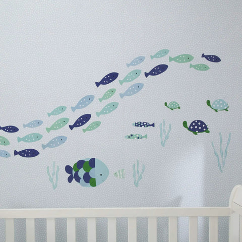 Oceania Aqua Blue Fish Wall Decals Set Easy Peel And Stick Ocean Themed Stickers with colorful school of fish and turtles above a crib