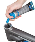 Park Tool GG-1 Fat Press, silver; side view of hand using blue press to install into bicycle head tube.