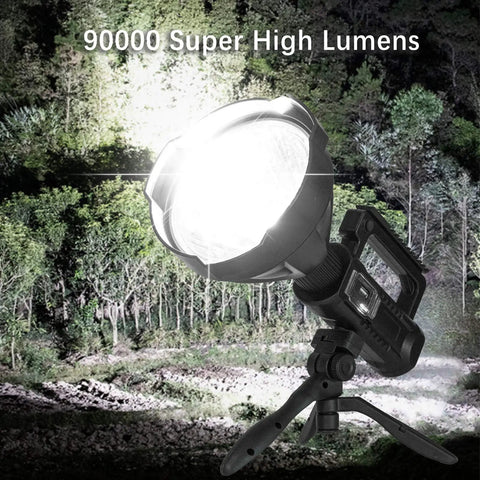 Beast Bright 900000 Lumen Rechargeable Handheld Spotlight With Tripod Mount USB Output illuminating forest at night.